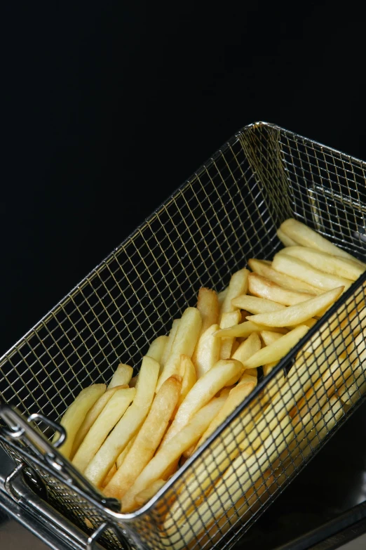 a basket filled with french fries sitting on top of a stove