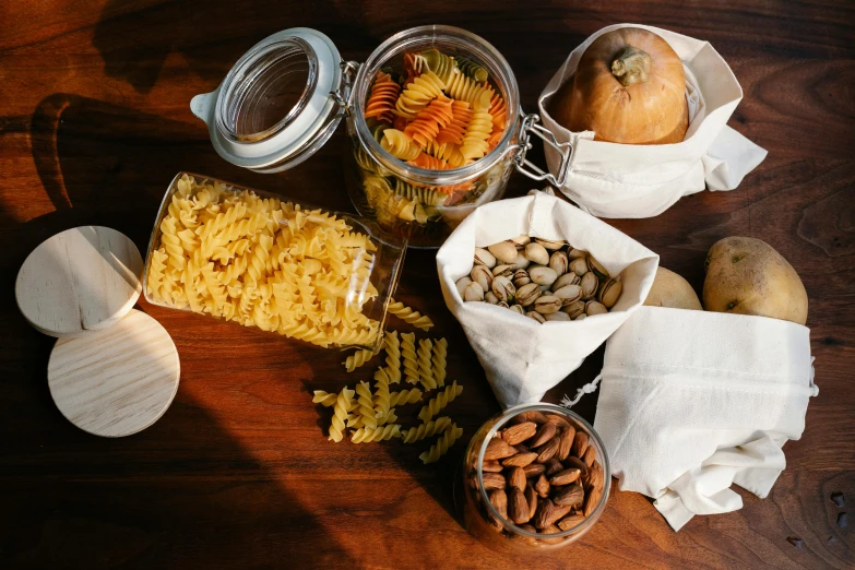 a bunch of food sitting on top of a wooden table, pexels contest winner, renaissance, jars, pasta, nut, 🦩🪐🐞👩🏻🦳