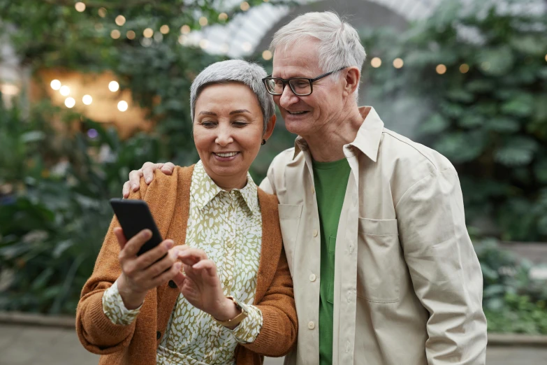 a man and woman standing next to each other looking at a cell phone, pexels contest winner, renaissance, older woman, wholesome, a green, coloured photo