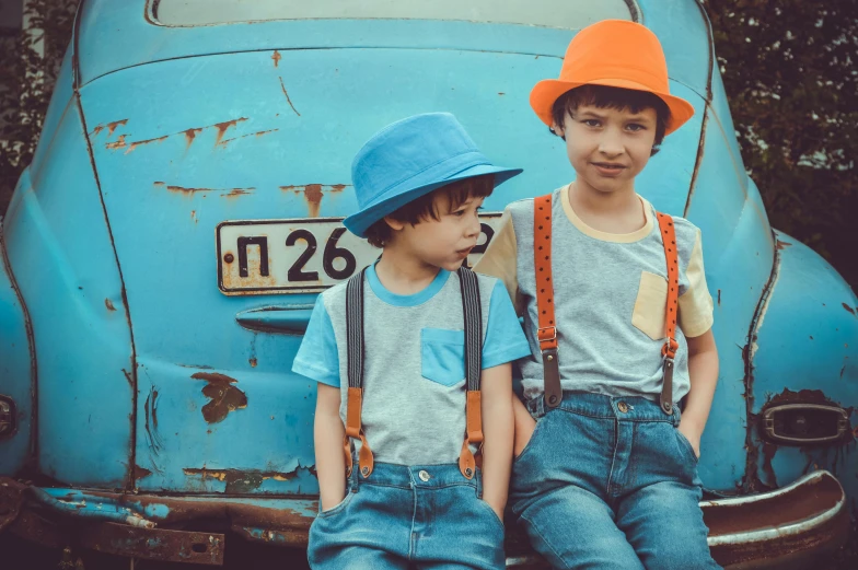 two young boys sitting on the back of a blue car, pexels contest winner, wearing a straw hat and overalls, avatar image, retro colour, cyan and orange