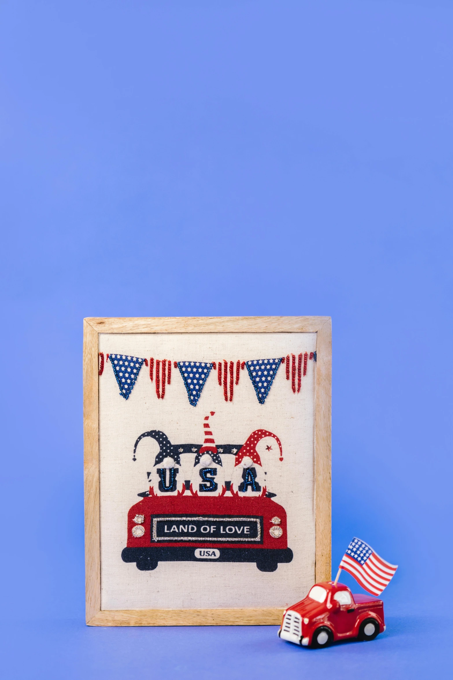 a red truck and an american flag on a blue background, a cross stitch, by Julia Pishtar, light box, parade, product introduction photo, decorative frame