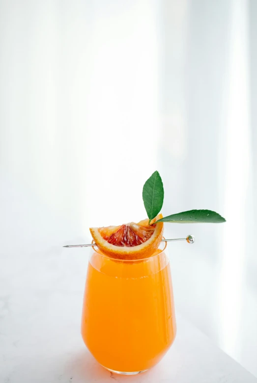 an orange drink with a garnish garnish garnish garnish garnish garnish garnish garn, by Nicolette Macnamara, trending on pexels, on a gray background, rays of sunshine, on a marble pedestal, tail fin