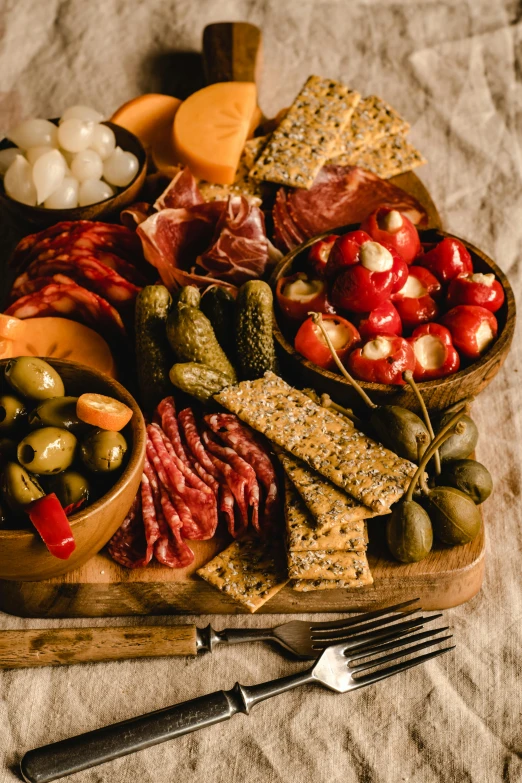 a close up of a plate of food on a table, cheese and salami on the table, on a wooden tray, 1 6 x 1 6, olives