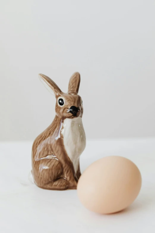 a small figurine of a rabbit next to an egg, inspired by Sarah Lucas, unsplash, brown tail, full product shot, breakfast, kangaroo