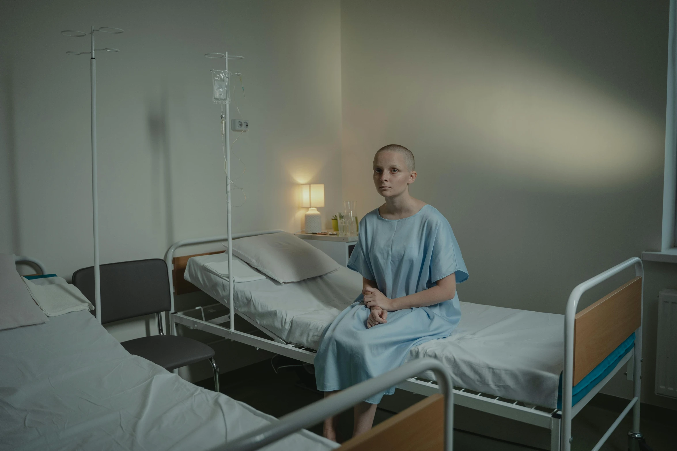 a man sitting on a hospital bed in a hospital room, a portrait, pexels contest winner, antipodeans, teenage girl, shaved head, ( ( theatrical ) ), full body 8k