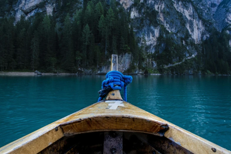 a boat on a lake with mountains in the background, pexels contest winner, process art, blue and green water, on the bow, dolomites, thumbnail