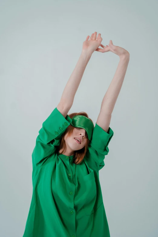 a woman in a green shirt is stretching her arms, an album cover, inspired by Harriet Powers, trending on pexels, blindfold, ignant, sleepwear, showstudio