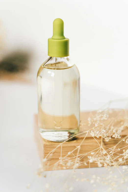 a bottle of liquid sitting on top of a table, a picture, unsplash, diffused natural skin glow, clean hair, resin, with a white background