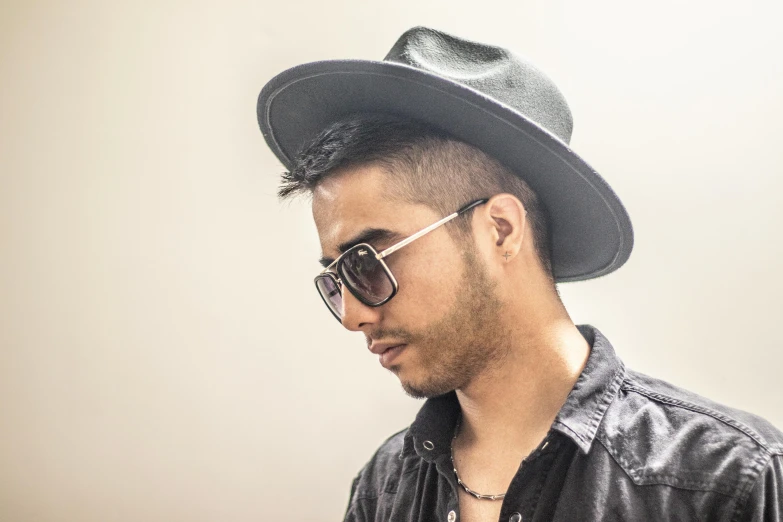 a man wearing a black hat and sunglasses, an album cover, inspired by Byron Galvez, profile image, square rimmed glasses, portrait mode photo, sideview