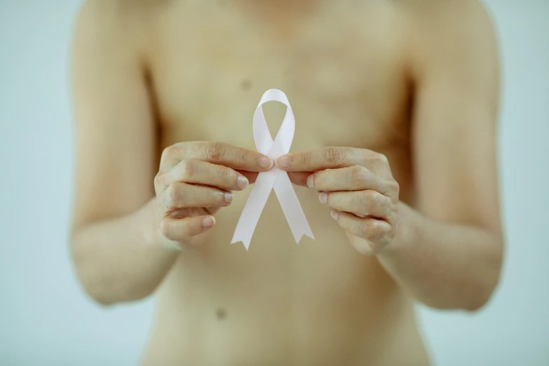a person holding a pink ribbon in their hands, by Julian Allen, trending on pexels, antipodeans, lean man with light tan skin, scales covering her chest, medical labels, slender boy with a pale