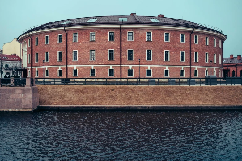 a large building next to a body of water, pexels contest winner, brick walls, russian academic, wes anderson background, barracks