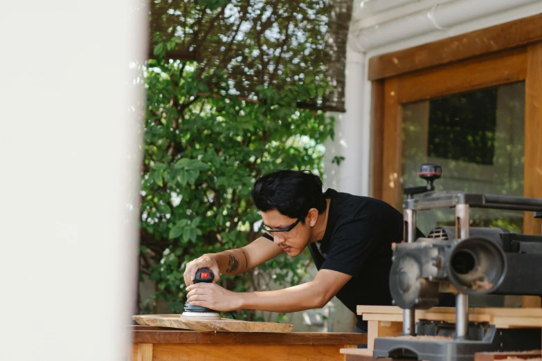 a man sanding a piece of wood with a sander, a portrait, by Robbie Trevino, pexels contest winner, ayami koj ima, gardening, profile image, architect