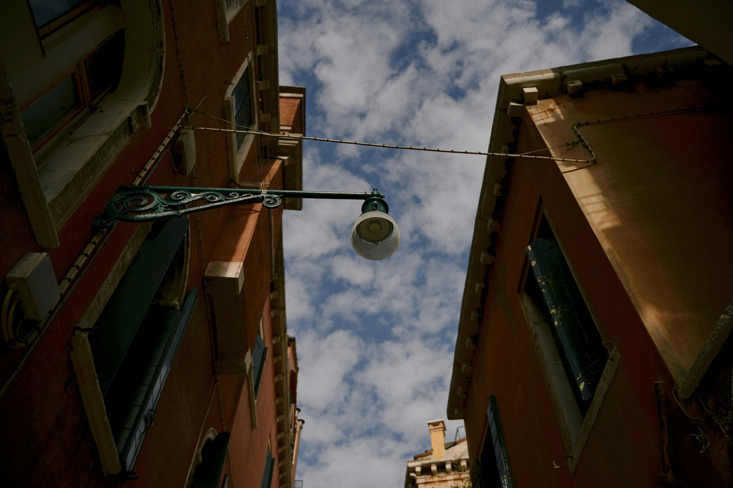 a street light hanging off the side of a building, a picture, unsplash contest winner, renaissance, venice biennale, summer sky, profile image, low angle fish eye lens