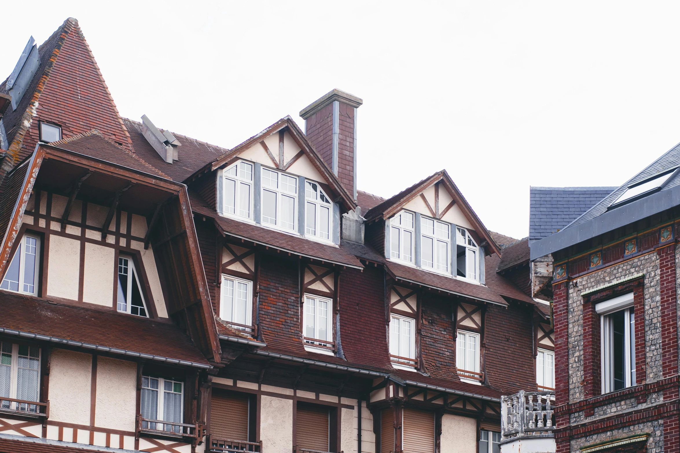 a couple of buildings that are next to each other, inspired by Albert Paris Gütersloh, unsplash, art nouveau, timbered house with bricks, 90s photo, france, 2000s photo