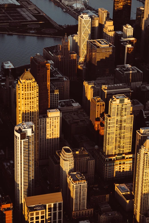 a city with lots of tall buildings next to a body of water, a screenshot, pexels contest winner, modernism, gold hour light, high angle vertical, sydney, chicago