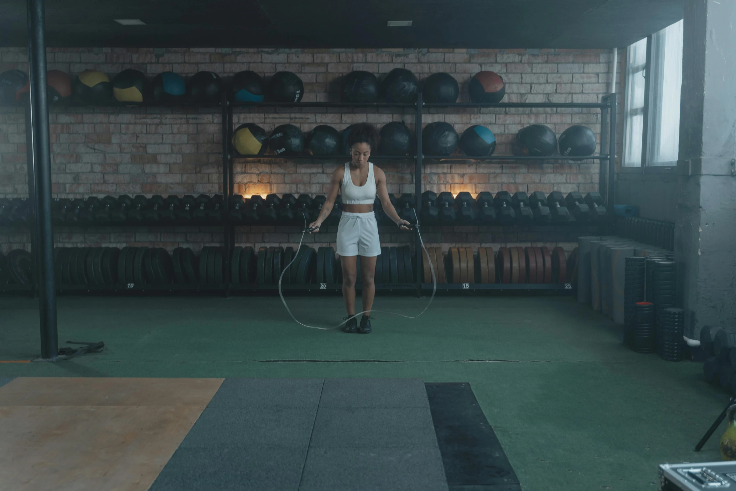 a woman holding a jump rope in a gym, pexels contest winner, low quality footage, full body 8k, faded glow, lachlan bailey