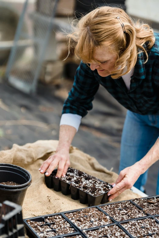 a woman tending to seedlings in a greenhouse, a portrait, unsplash, “ iron bark, ground breaking, foam, black