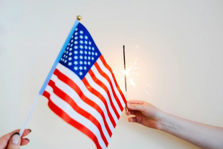 a person holding a sparkler and an american flag, a picture, decoration, profile image, fan favorite, full product shot