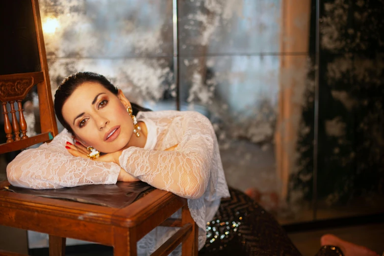 a woman sitting on top of a wooden chair, a portrait, by Myra Landau, pixabay, hurufiyya, shohreh aghdashloo, on a white table, charli xcx, glittering light