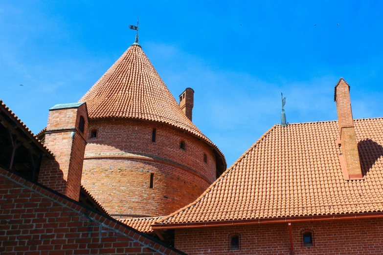 a red brick building with a blue sky in the background, by Adam Marczyński, pexels contest winner, romanesque, rounded roof, nordic crown, thumbnail, square