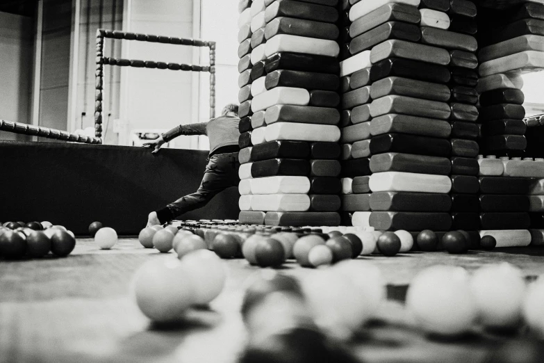 a pile of books sitting on top of a wooden floor, a black and white photo, by Matthias Weischer, unsplash, process art, in a ball pit, athlete photography, ffffound, working out