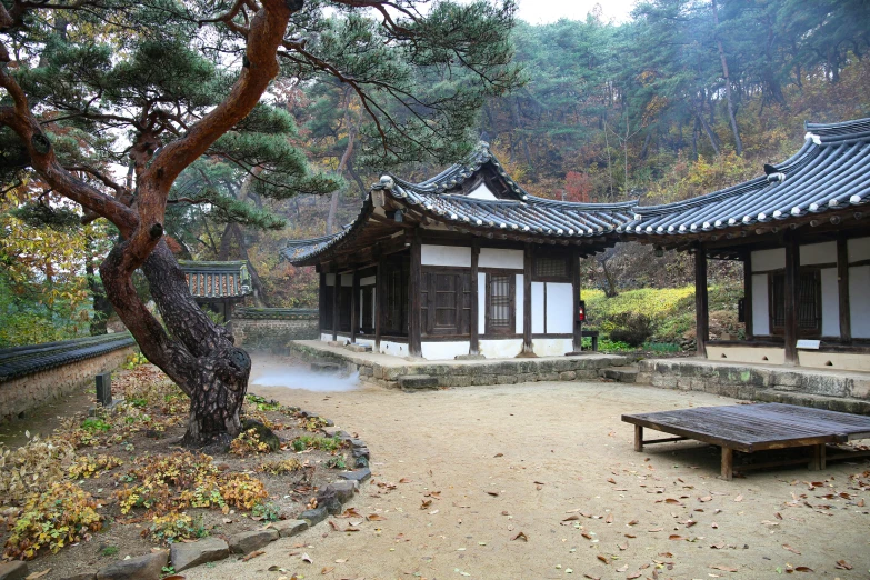 a wooden bench sitting in the middle of a courtyard, inspired by Kim Hong-do, unsplash contest winner, korean traditional palace, under a gray foggy sky, square, fall season