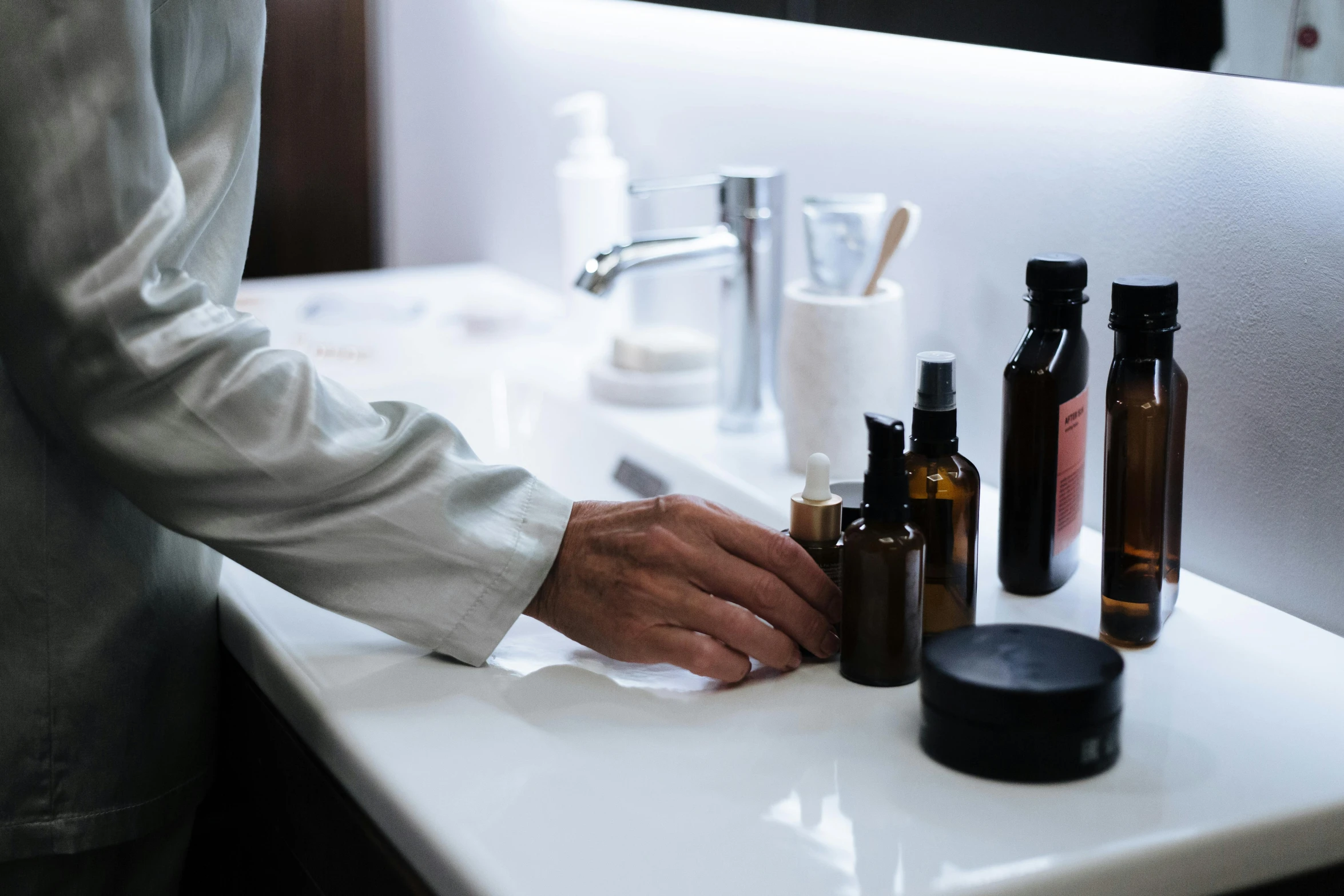 a man that is standing in front of a sink, a still life, unsplash, apothecary, profile image, back of hand on the table, japanese collection product