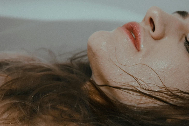 a close up of a person laying in a bathtub, inspired by Elsa Bleda, trending on pexels, hyperrealism, messy brown hair, dreaming of kissing a girl, silicone skin, laying on a bed