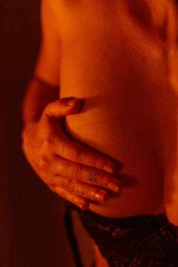 a woman with her hands on her belly, inspired by Nan Goldin, massurrealism, himalayan rocksalt lamp, sores and scars, promo image, vibrant realistic