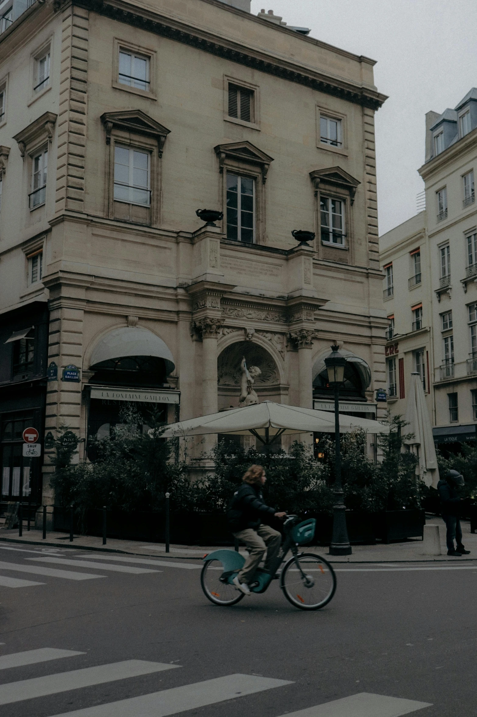 a person riding a bike on a city street, pexels contest winner, paris school, restaurant in background, square, low quality photo, neoclassicism style