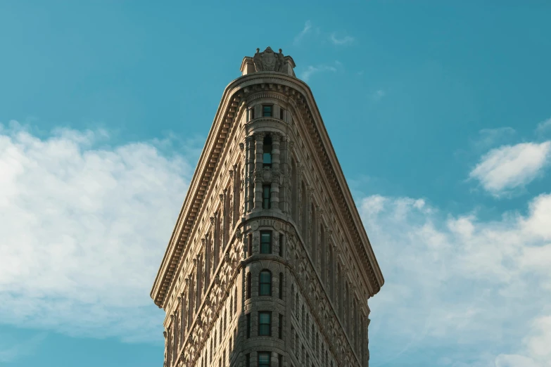 a tall building with a clock on top of it, by Andrew Domachowski, unsplash contest winner, art nouveau, clear blue skies, in new york, curvy build, brown