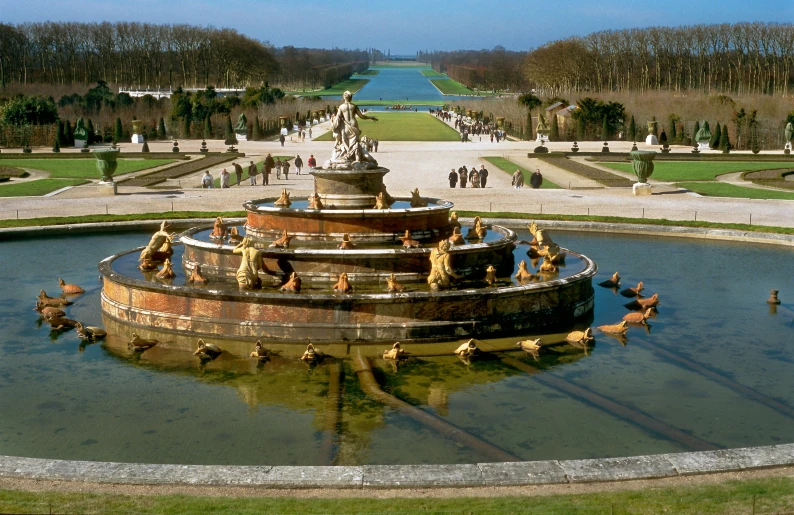 a large fountain sitting in the middle of a park, an album cover, inspired by Édouard Detaille, pexels contest winner, baroque, canals, wide high angle view, terraced orchards and ponds, mies van der rohe