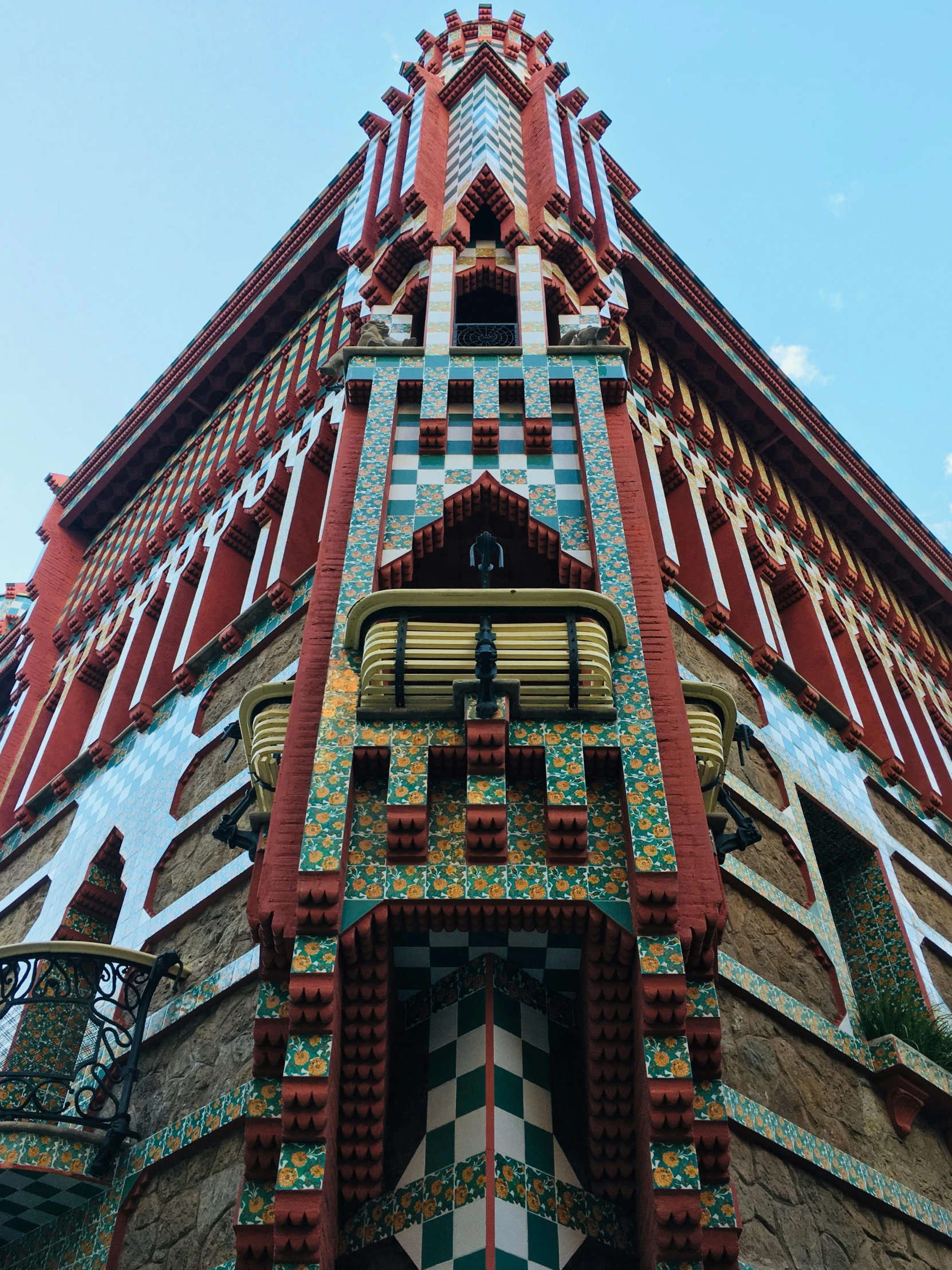 a tall building with a clock on it's side, by Gaudi, pexels contest winner, art nouveau, vibrant red and green colours, extremely detailed frontal angle, beautiful moorish tiles, looking towards camera