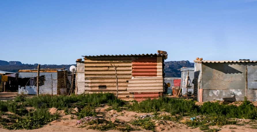 a couple of shacks sitting next to each other, a portrait, unsplash, south african coast, realistic »