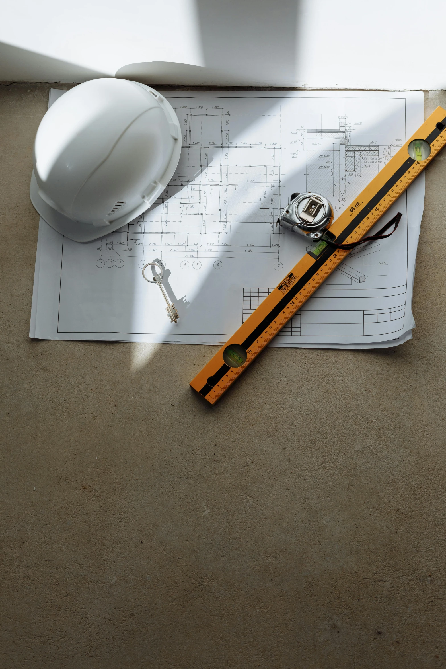 a white hard hat sitting on top of a table next to a ruler, pexels contest winner, floor plan view, concrete, brown, white