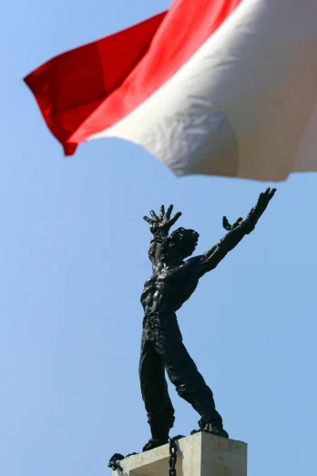 a statue of a man holding a flag on top of a building, a statue, by Jacek Sempoliński, happening, jokowi, hands in the air, photographed for reuters, square