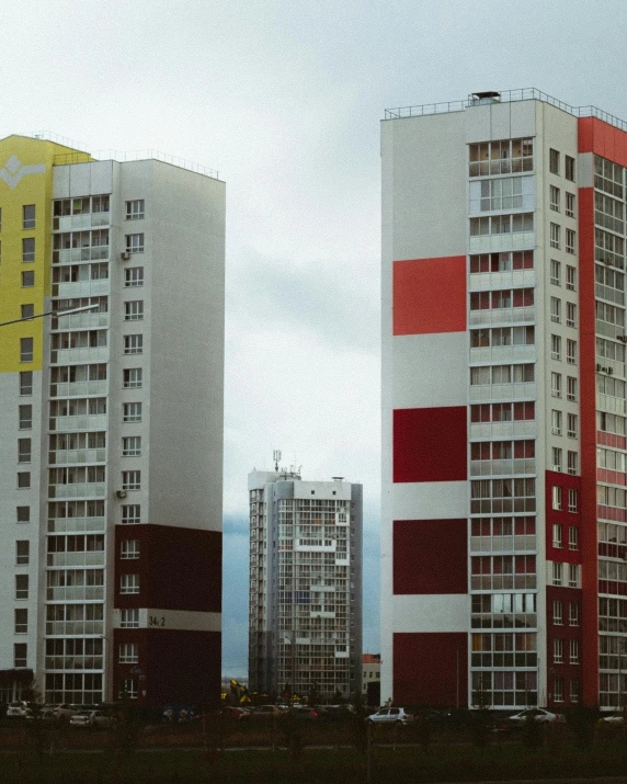 a couple of tall buildings sitting next to each other, a colorized photo, by Attila Meszlenyi, unsplash, socialist realism, gay pride, soviet suburbs, three towers, beautiful russia of the future