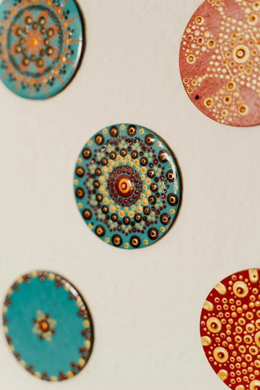 a group of magnets sitting on top of a refrigerator, an ultrafine detailed painting, inspired by Damien Hirst, trending on pexels, cloisonnism, mandala ornament, high angle close up shot, brown, made of glazed