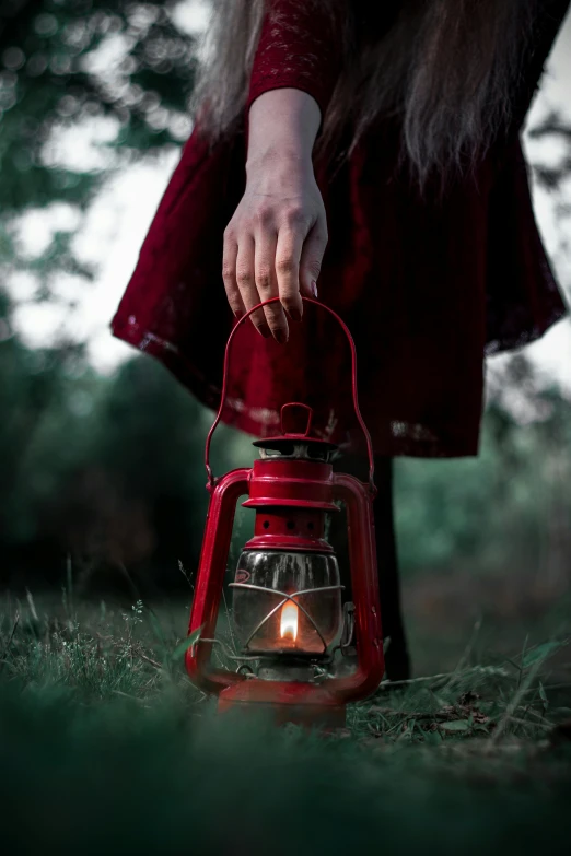 a woman in a red dress holding a red lantern, pexels contest winner, camping, holding a candle holder, about to step on you, maroon