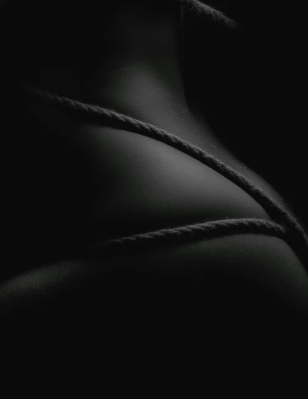 a black and white photo of a woman's back, by Adam Marczyński, conceptual art, rope, all black matte product, jaquet droz, teaser