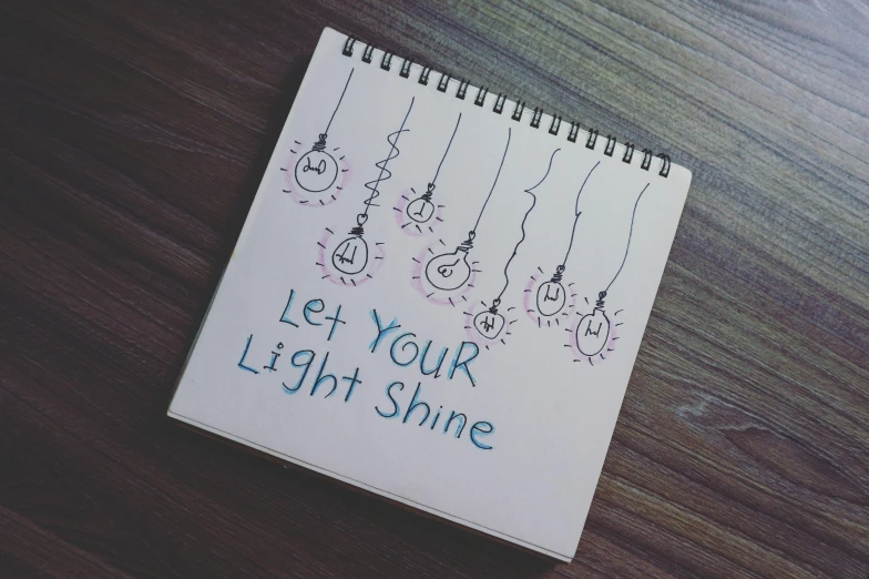 a notebook with the words let your light shine written on it, an album cover, pixabay, poorly drawn, overhead light, bts, highly accurate