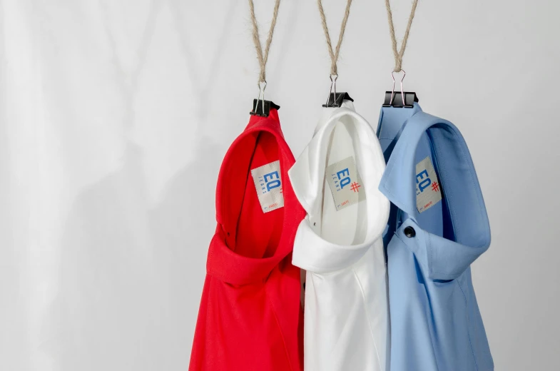 three shirts hanging on a clothes hanger, inspired by Eugène Brands, blue or red, eeri, labcoat, wearing polo shirt