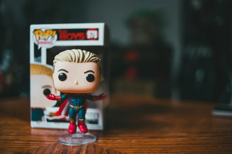 a close up of a pop vinyl figure on a table, pexels, homelander from the boys, a blond, super heroes, the boys