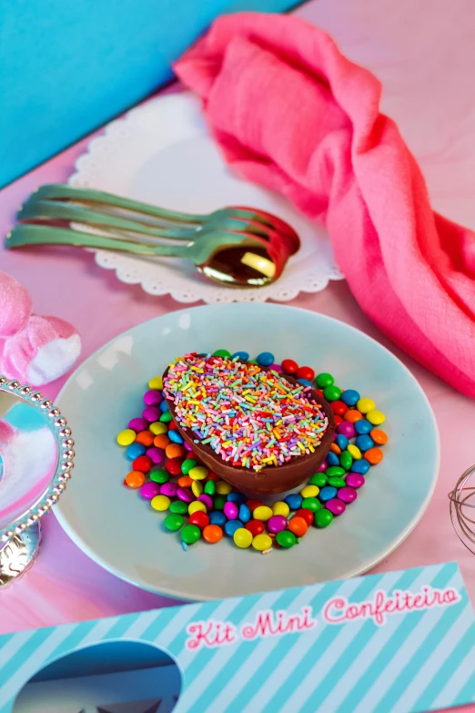 a white plate topped with a chocolate cake covered in sprinkles, pop art, place setting, candy pastel, 2019 trending photo