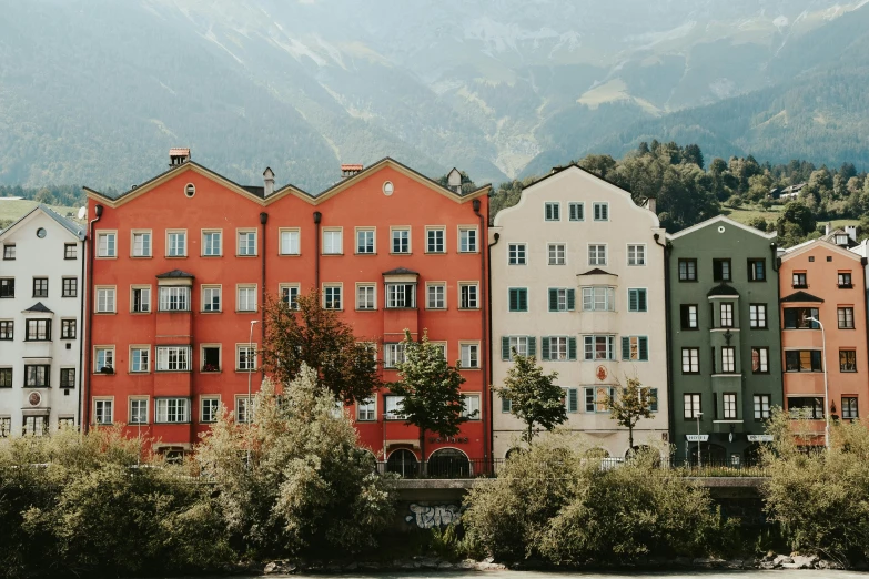 a row of colorful buildings next to a body of water, a photo, by Tobias Stimmer, pexels contest winner, art nouveau, alpine architecture, still from a wes anderson film, slightly tanned, building along a river