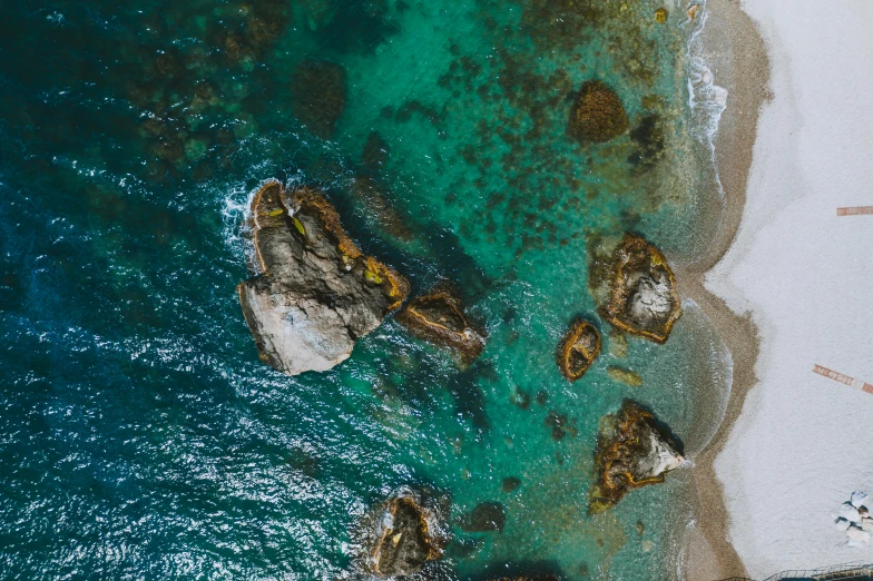 a group of people standing on top of a beach next to a body of water, pexels contest winner, hd aerial photography, abel tasman, reefs, thumbnail