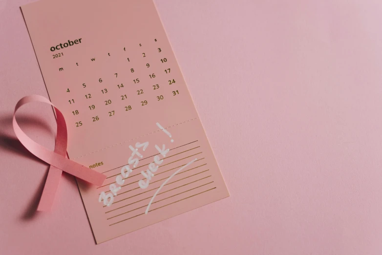 a calendar with a pink ribbon on top of it, by Carey Morris, pexels contest winner, happening, pink skin, background image, october, diecut