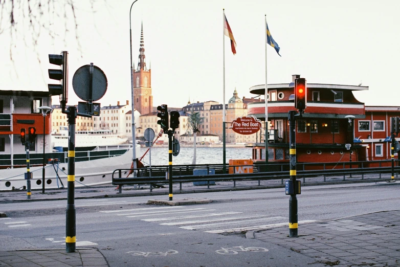 a couple of traffic lights sitting on the side of a road, by Tobias Stimmer, pexels contest winner, visual art, stockholm city, harbour in background, f 1.4 kodak portra, square