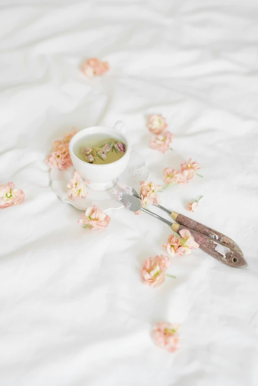 a cup of tea and a pair of scissors on a bed, by Anna Boch, trending on unsplash, romanticism, smeared flowers, on white, soup, low quality photo