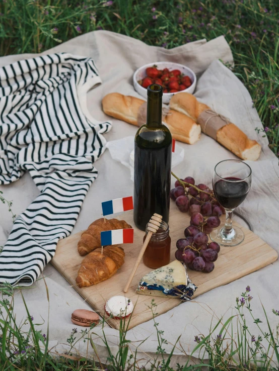 a bottle of wine sitting on top of a blanket, inspired by Jules Bastien-Lepage, pexels contest winner, patriotic, eating cheese, baking french baguette, striped